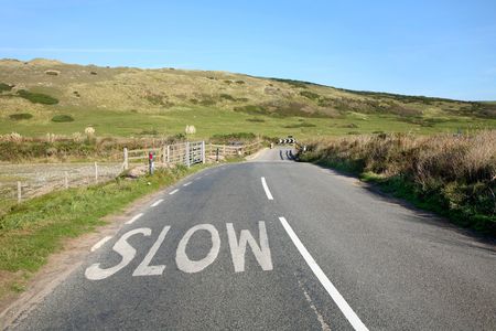 An English country road in Cornwall and a slow sign.の写真素材