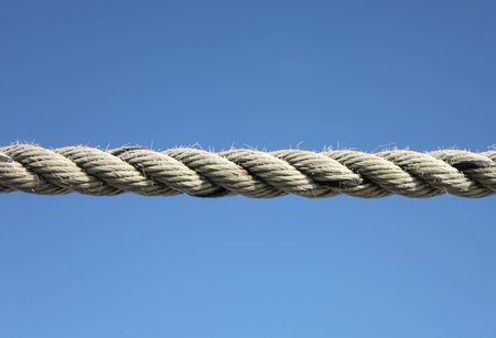 Close up of a boat mooring rope and a blue sky.
