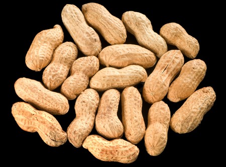 Roasted monkey nuts isolated over black.