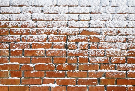 Snow sticking to an old brick wall.の写真素材