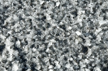 Melting snow slush on a road close up natural abstract background.