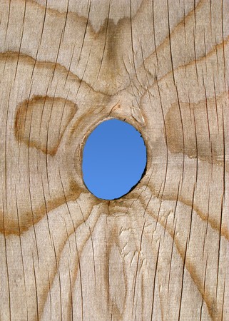 A peep hole in a wooden fence.の写真素材