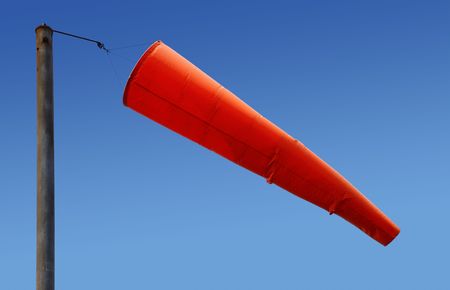 Airport orange windsock blowing in the wind.の写真素材