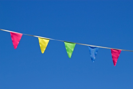Small colorful flags and a blue sky.の写真素材