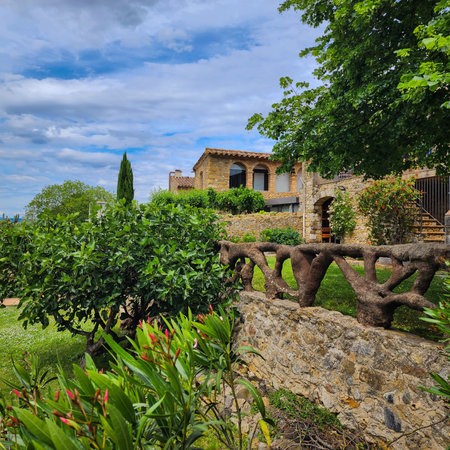 Beautiful villa with garden and flowers in springtime. Countryside landscape and dramatic cloudy sky. Catalonia. Spain.の写真素材