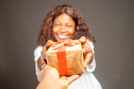 Young african woman over isolated gray background pointing finger upの写真素材