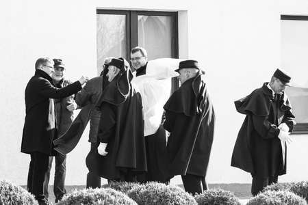 A priest with assistants preparing for a funeral ceremony