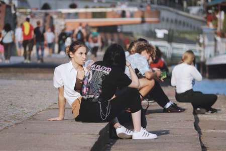 Gorzow Wielkopolski, Poland - young people sitting on the promenade and chattingのeditorial素材