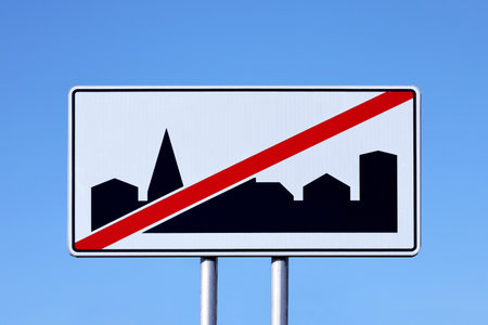 "End of built-up area" road sign on a blue sky background.の写真素材