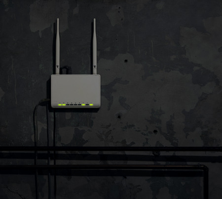Wi-Fi router on an old wall in a dark room - backgroundの写真素材