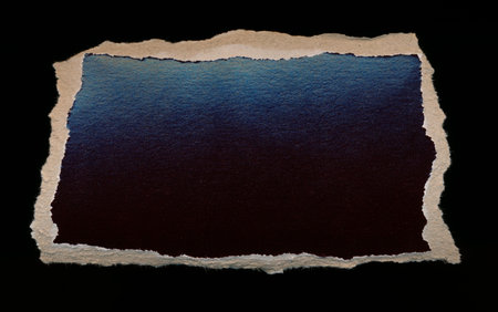Torn piece of dark paper, background for banner. Blank paper piece message, reminder, sign, tag, label. Ripped cardboard empty background. Design element. Isolated on black. Copy space, place for textの写真素材