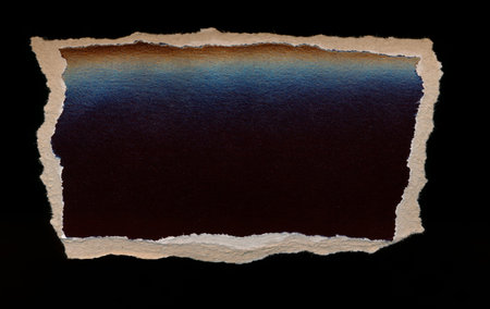 Torn piece of dark paper, background for banner. Blank paper piece message, reminder, sign, tag, label. Ripped cardboard empty background. Design element. Isolated on black. Copy space, place for textの写真素材