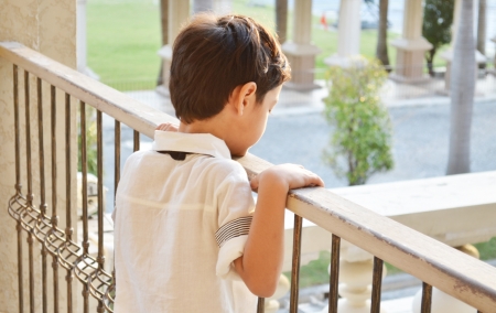 Little boy standing alone at balconyの写真素材
