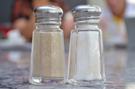 Glass salt and pepper shakers on table in restuarantの写真素材