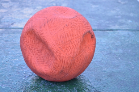 Old empty air orange ball on the groundの写真素材