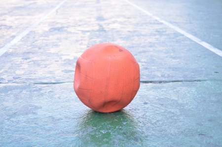 Old empty air orange ball on the groundの写真素材