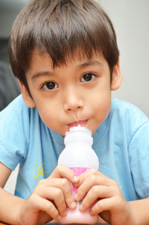 Little boy drinking milk strawberry favorの写真素材