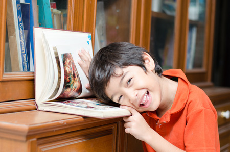 Little Boy in library holding bookの写真素材