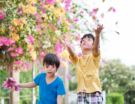 Little sibling boy throw flowers in to the airの写真素材