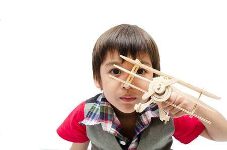 little boy playing with a toy airplane. Isolated on white backgroundの写真素材