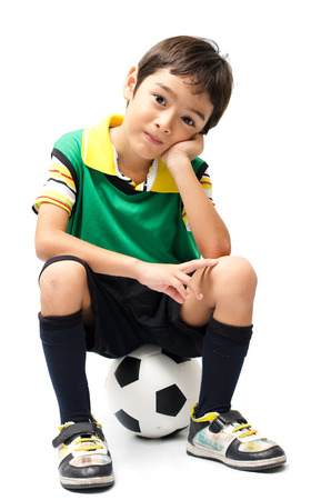 Little boy sitting on football on white backgroundの写真素材