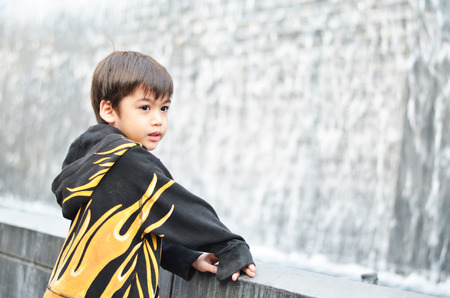 Little boy looking at waterfall fountainの写真素材