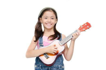 Little girl playing ukulele on white backgroundの写真素材