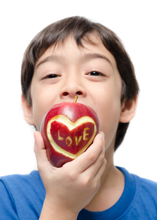 Little boy eating apple , love word on skin focus on appleの写真素材
