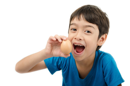 Little boy holding egg in hand mouth wide healthy on white backgroundの写真素材