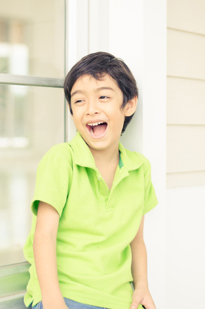 Little boy sitting at the window with happy faceの写真素材