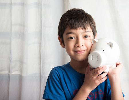 Little boy take a saving money in piggy bankの写真素材