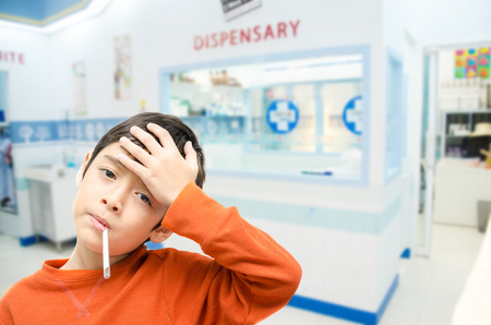 Little sick boy with temperature in mouth in hospital