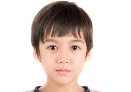 Little boy taking photo portrait with beautiful eyes on white backgroundの写真素材