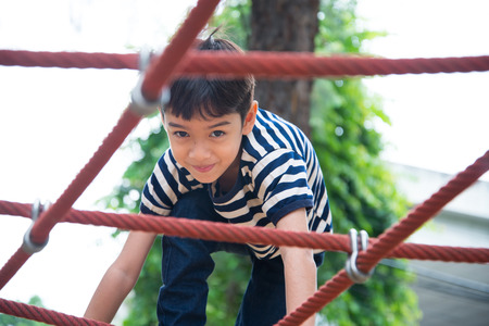 Little boy climbing rope at plagroundの写真素材