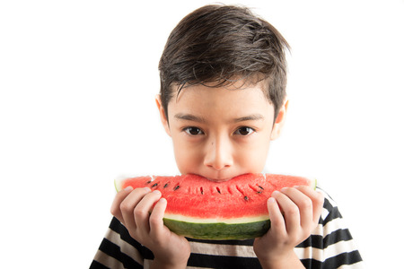 Little boy eating watermelin on white backgroundの写真素材