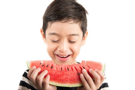 Little boy eating watermelon on white backgroundの写真素材