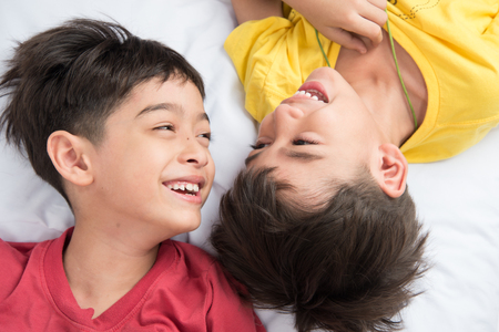 Little sibling boy lay on the pillow  togetherの写真素材