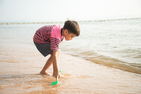 Little boy playing sand on the beach summer timeの写真素材