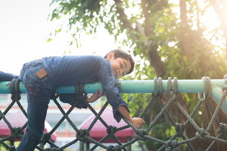 Little boy climbing on the rope at playgroundの写真素材