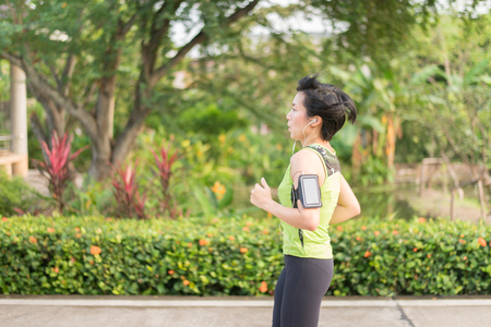 Asian woman running in the park healthyの写真素材
