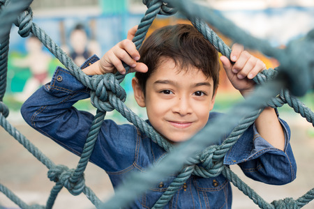 Little boy climbing on the rope at playgroundの写真素材
