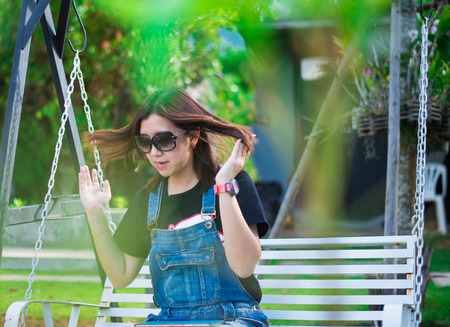 Beautiful asian woman sitting on swing chairの写真素材
