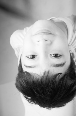 Little boy looking up with smiling on white backgroundの写真素材