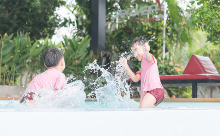 Little boy playing water at swimming pool inthe hotelの写真素材