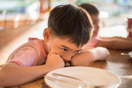 Little boy waiting for food in the restuarang outdoor