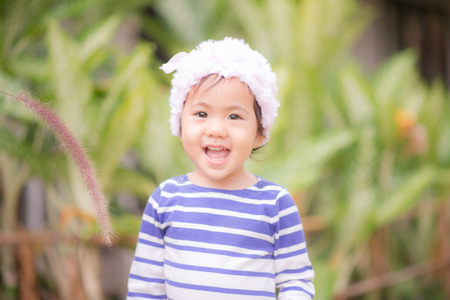 Little cute asian girl touching flower grass  vintage filterの写真素材