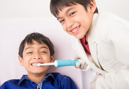 Little sibling boy pretend as a dentist vLittle sibling boy pretend as a dentist close up inside mouth check upの写真素材