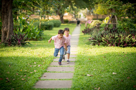 Little sibling boy playing together in the parkの写真素材