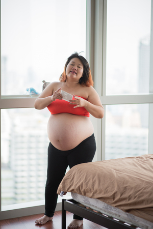 Happy mother Pregnancy belly skin close up sit on the bedの写真素材