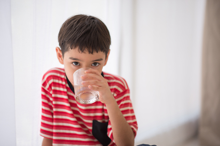Little boy drinking waterの写真素材